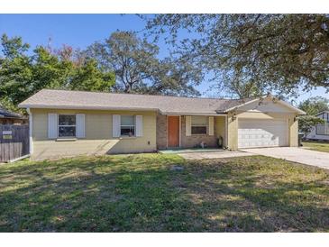 Ranch-style home with attached garage,mature landscaping, and a spacious yard at 137 N Nowell St, Orlando, FL 32835