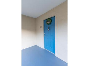 Inviting condo front door painted bright blue with wreath and secure electronic lock at 7240 Westpointe Blvd # 1115, Orlando, FL 32835