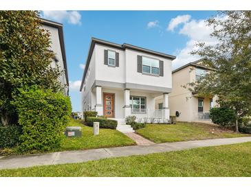 Two-story house with modern facade, front porch, and landscaped lawn at 7859 Summerlake Groves St, Winter Garden, FL 34787