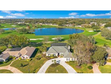 Expansive golf course home featuring a beautiful lake view and well-manicured landscaping at 8513 Bay Hill Blvd, Orlando, FL 32819