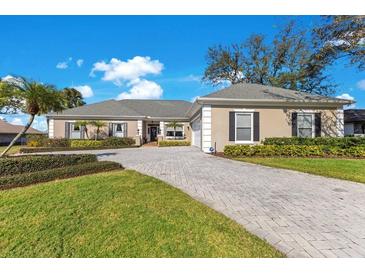 Charming home with a manicured lawn, beautiful landscaping and a spacious brick driveway at 8513 Bay Hill Blvd, Orlando, FL 32819