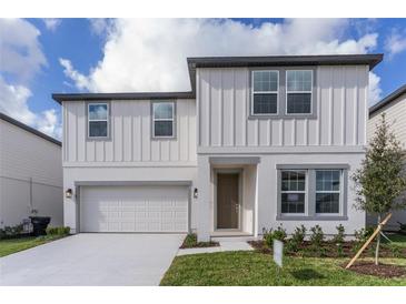 Two-story house with white siding, gray accents, and a two-car garage at 2058 Derwent Dr, Davenport, FL 33896