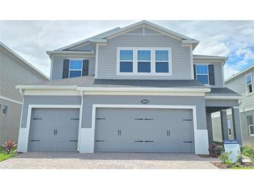Charming two-story home features a two-car garage and a modern gray facade at 2678 Great Heron Ave, St Cloud, FL 34773