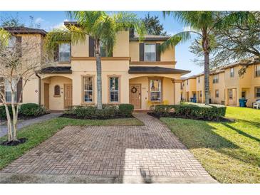 Two-story townhome with brick paver driveway and landscaping at 2735 Calabria N Ave, Davenport, FL 33897