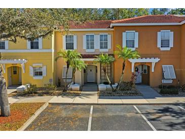 Two-story townhouses with attractive light-yellow and orange exteriors at 1005 Park Ridge Cir, Kissimmee, FL 34746