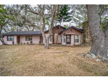 Ranch style home with mature landscaping and large oak trees at 120 Sunset Blvd, Polk City, FL 33868