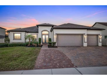 Two-story house with a three-car garage, and a landscaped front yard at 1954 Filly Trl, Oviedo, FL 32765