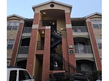 Exterior view of a three-story apartment building with a central staircase at 1979 Summer Club Dr # 309, Oviedo, FL 32765