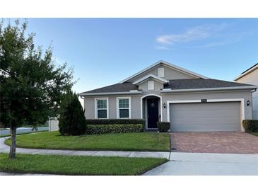 One-story house with gray siding, a two-car garage, and a well-manicured lawn at 3333 Wauseon Dr, Saint Cloud, FL 34772