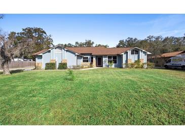 Single-story home with blue siding, brown roof, and a spacious lawn at 3425 Suzette Dr, Kissimmee, FL 34746