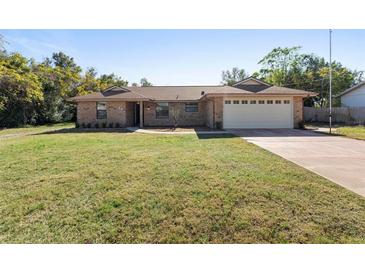 Brick ranch home with attached two-car garage and spacious lawn at 43 Dahlia Dr, Debary, FL 32713