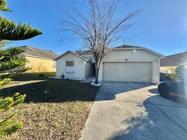 Single-story house with attached garage and driveway at 551 Lake Charles Dr, Davenport, FL 33837