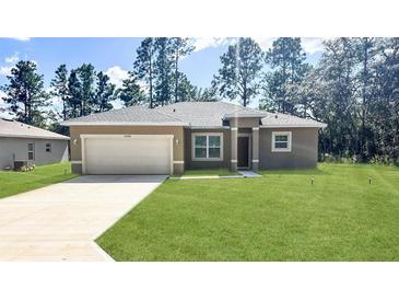 New construction home with attached garage and grassy lawn at 5998 Sw 154Th Street Rd, Ocala, FL 34473