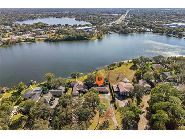 Aerial view of lakefront property with lush landscaping and spacious homes at 754 E Wildmere Ave, Longwood, FL 32750