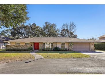 House exterior featuring a red door and stone facade at 754 E Wildmere Ave, Longwood, FL 32750