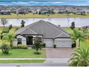 Aerial view of a single-Gathering home with a lake view and a large backyard at 17608 Sailfin Dr, Orlando, FL 32820