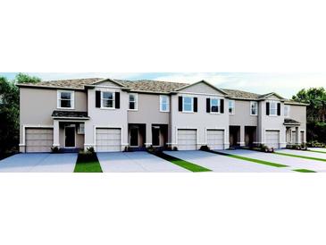 Front view of a row of townhouses with attached garages and landscaping at 2211 Tongass Bnd, Davenport, FL 33896