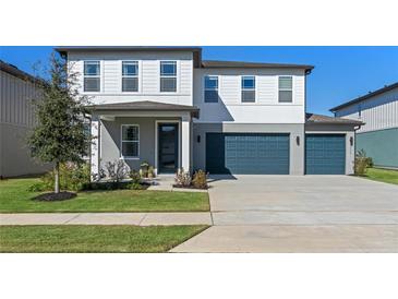 Two-story house with gray siding, white trim, and a two-car garage at 2338 Gold Dust Dr, Minneola, FL 34715