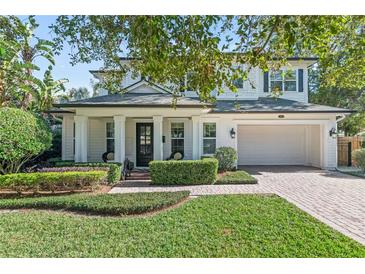 Two-story white house with a brick walkway, lush landscaping, and a two-car garage at 3513 Pinetree Rd, Orlando, FL 32804