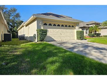 Single car garage with light beige door and landscaping at 5119 Santa Ana Dr, Orlando, FL 32837