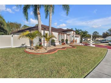 Landscaped front yard with palm trees and a fountain at 539 Pinehurst Cv, Kissimmee, FL 34758