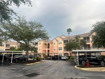 Exterior view of condo building with parking and landscaping at 13536 Turtle Marsh Loop # 538, Orlando, FL 32837