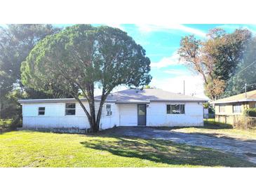 White single story home with a large tree in the front yard at 1416 Wilton Ave, Orlando, FL 32805