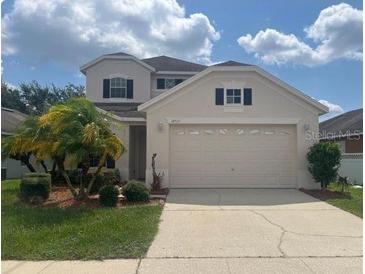 Two-story house with a two-car garage and landscaped front yard at 14515 Huntcliff Park Way, Orlando, FL 32824