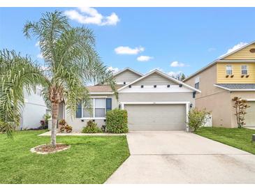 Charming one-story house with a gray exterior, two-car garage, and landscaped lawn at 306 Kettering Rd, Davenport, FL 33897