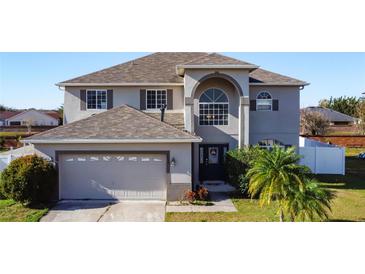 Two-story house with a gray exterior, two-car garage, and landscaped yard at 5417 Calla Lily Ct, Kissimmee, FL 34758