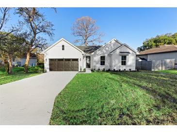 Charming farmhouse-style home with a dark brown garage door and manicured lawn at 58 Bonita Rd, Debary, FL 32713