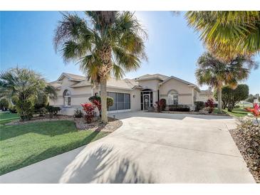 Single-story home with palm trees, landscaped yard, and circular driveway at 5942 Nw 26Th Ln, Ocala, FL 34482