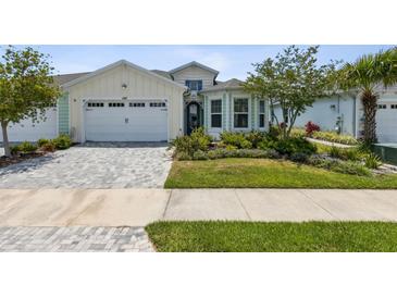 House exterior featuring a two-car garage and well-manicured lawn at 597 Lost Shaker Way, Daytona Beach, FL 32124