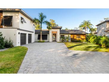 Two-story home with a paver driveway and palm trees at 7 1 St Ct, Windermere, FL 34786