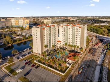 Aerial view of a modern apartment building with pool and parking at 7383 Universal Blvd # 207, Orlando, FL 32819