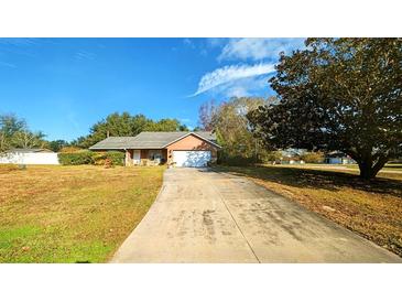 Cute one-story house with a large yard and driveway at 9913 Janette Ln, Clermont, FL 34711