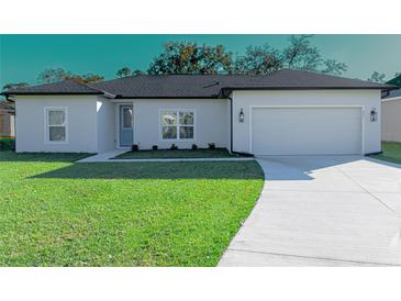 Newly constructed home with a two-car garage and well-manicured lawn at 227 W 4Th St, Chuluota, FL 32766