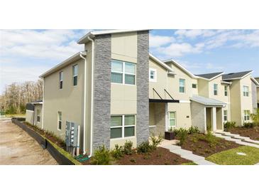 Modern two-story townhome with stone accents and landscaped walkway at 4355 Scene Ln, Kissimmee, FL 34746