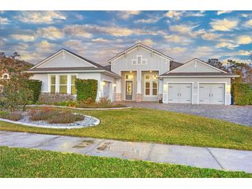 Two-story home with gray siding, three-car garage, and landscaped front yard at 2423 Hyatt Creek Ln, Port Orange, FL 32128