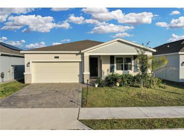 House exterior featuring a two-car garage and well-manicured lawn at 3087 Camden Way, Davenport, FL 33837