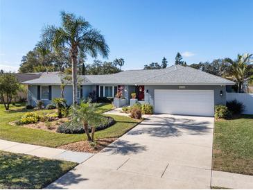Single-story home with landscaped yard, attached garage, and palm trees at 8134 Hook Cir, Orlando, FL 32836