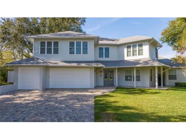 Two-story house with gray exterior, double garage, and manicured lawn at 8679 Harbor View Dr, Orlando, FL 32817