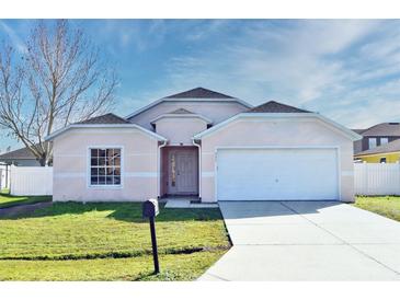 Cute one-story house with a two-car garage and a well-maintained lawn at 997 Gascony Ct, Kissimmee, FL 34759