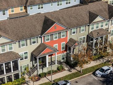 Aerial view of townhouses with lake, landscaping, and nearby sports field at 1074 Clifton Springs Ln, Winter Springs, FL 32708