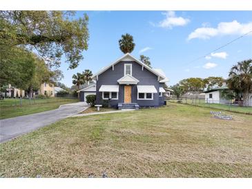 Gray house with white accents, a wooden door, and a spacious lawn at 119 Leon Ave, Deland, FL 32720