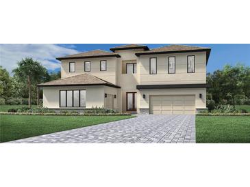 Two-story house with light beige walls, gray roof, and a paved driveway at 16800 Bolsena Dr, Montverde, FL 34756