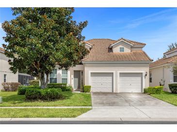 Two-story house with beige exterior, double garage, and landscaping at 2549 Archfeld Blvd, Kissimmee, FL 34747