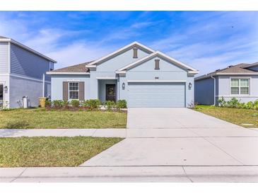 Light blue one-story house with a two-car garage and landscaped lawn at 3979 Ambrose Ave, Kissimmee, FL 34746