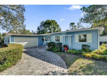 Ranch style home with a brick paver driveway and mature landscaping at 5408 Kalmia Dr, Orlando, FL 32807