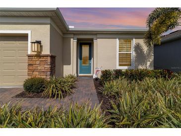 Inviting exterior with teal front door, landscaping, and brick walkway at 6145 Citrus Grove Ct, St Cloud, FL 34771